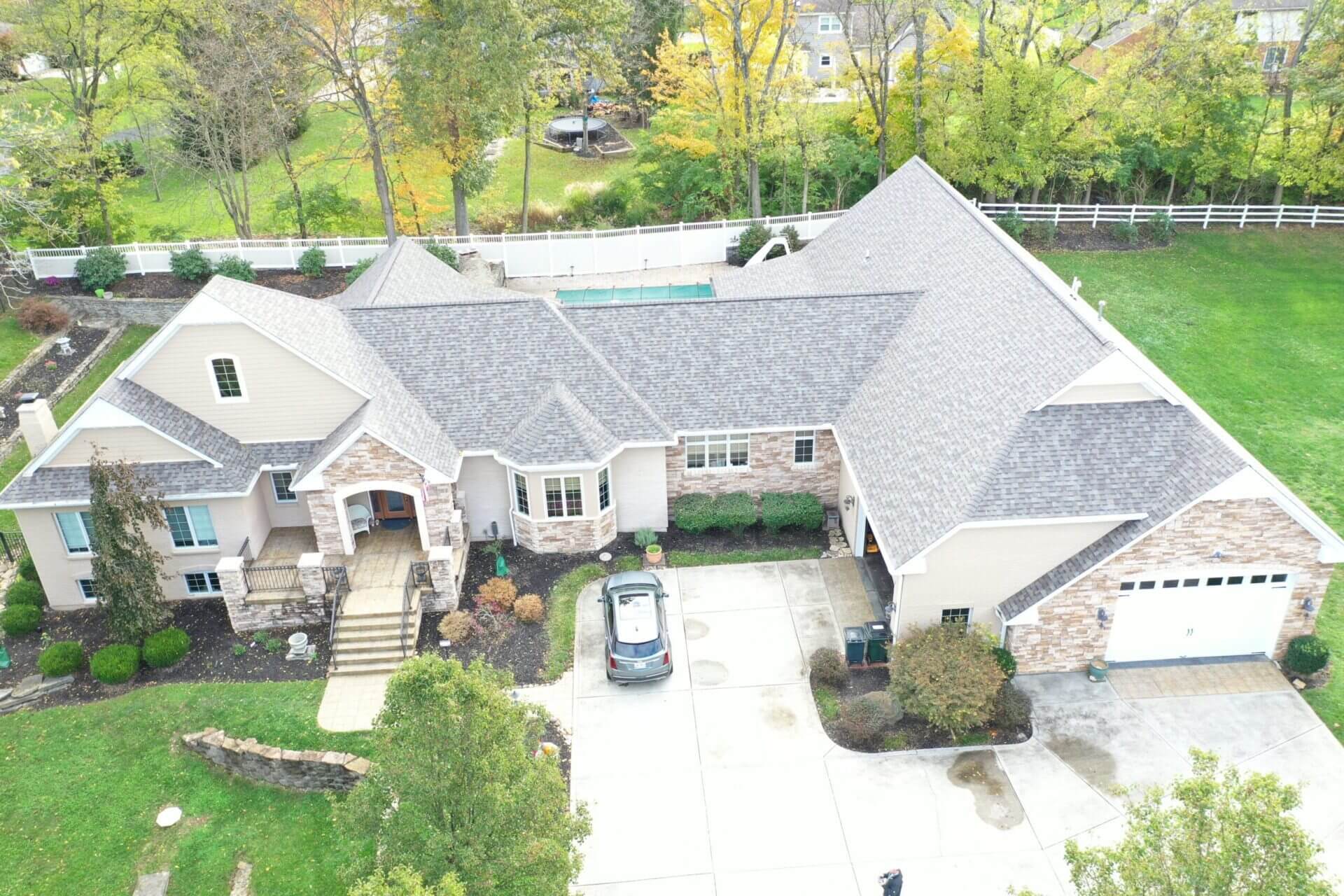 A aerial view of a house with a pool in the yard.